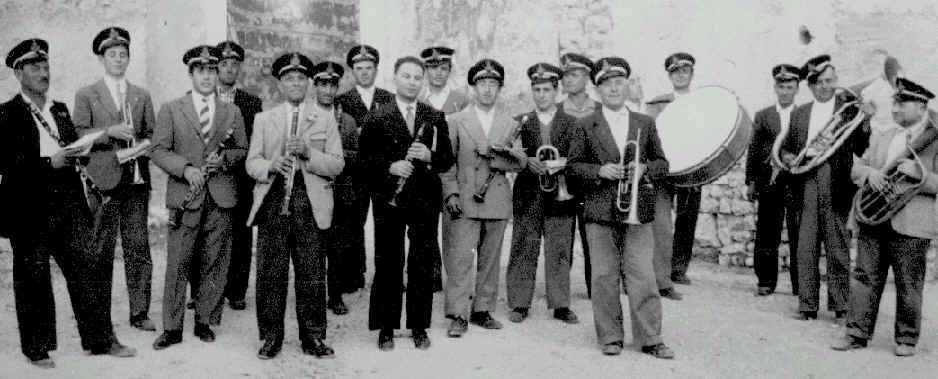 Foto della banda nel 1951. Tutti gli elemnti sono in piedi in ordine sparso e ognuno ha in mano il proprio strumento.
